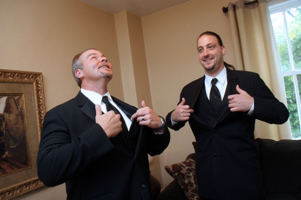 The groomsman and best man try to stay cool under the ceiling fan.